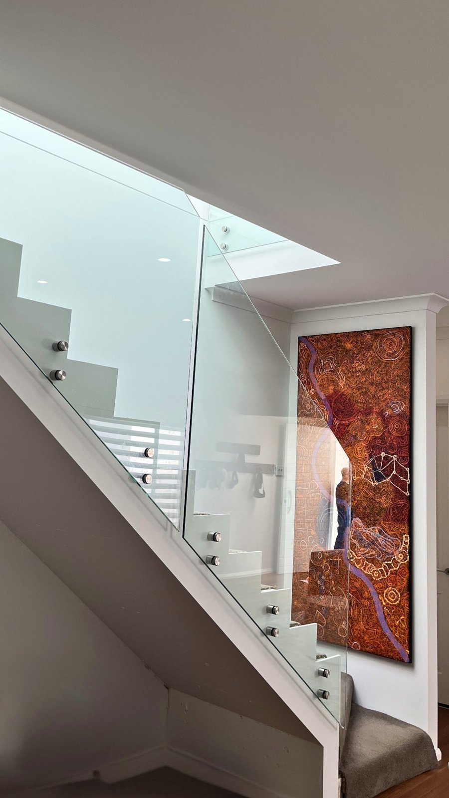 Standoff-fixed clear glass following the stair, artwork visible straight through - Clear glass stair balustrade replacement - Leichhardt