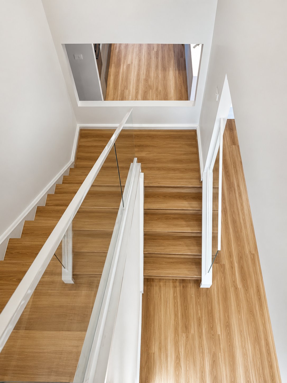 Looking down the stairwell - channel-set glass on both flights, no visible fixings - Channel base low iron (Sapphire) glass balustrade - Kellyville