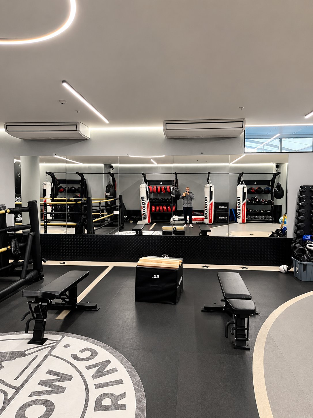 The finished run of mirrors reflecting the ring and heavy bags - Gym mirror installation - fight gym, Leichhardt Shopping Centre