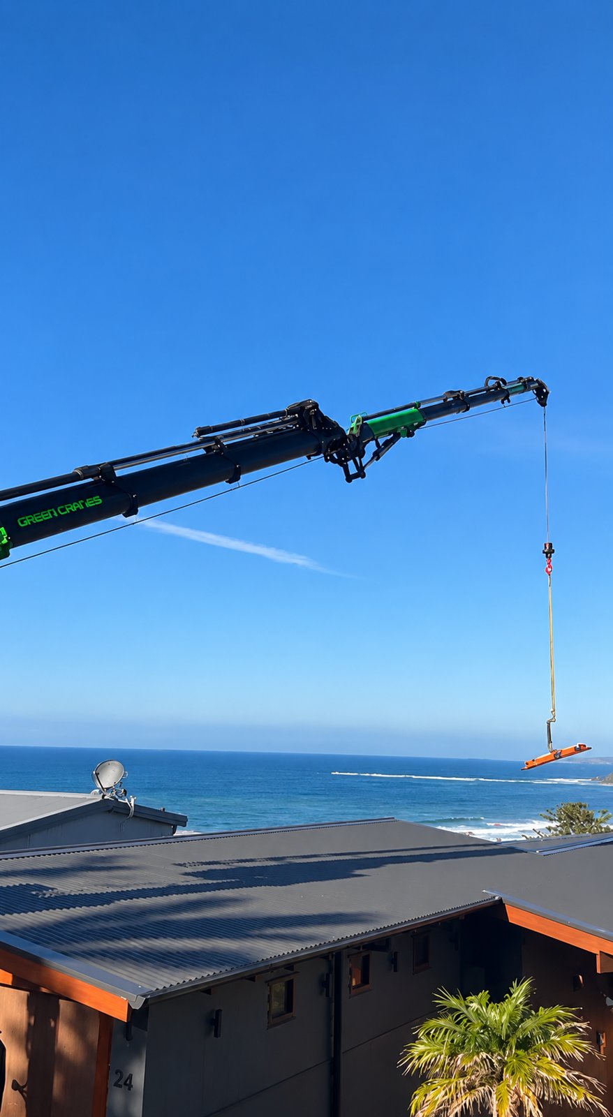 Crane set up to swing the new panel over the roof from the street - Crane-lift window glass replacement - Palm Beach