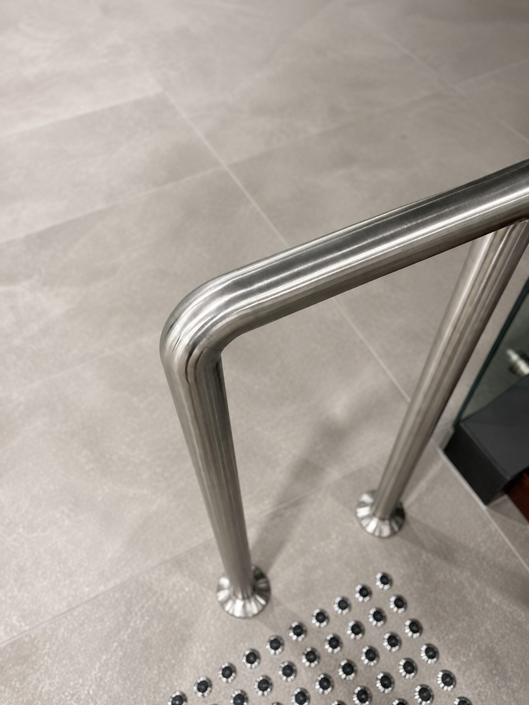 Handrail posts finished flush to the tiled floor - Commercial stair handrails, Sydney