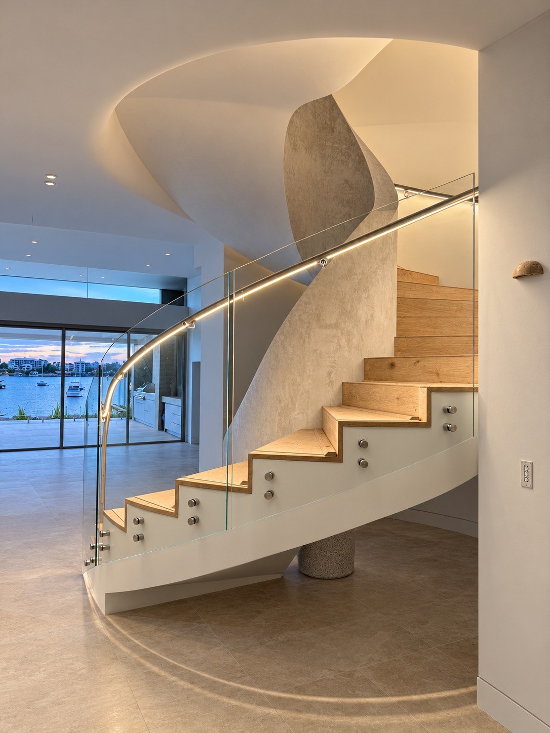 Curved low iron glass stair balustrade with LED stainless steel handrail at a Tennyson Point waterfront home - installed by Fusion Glass